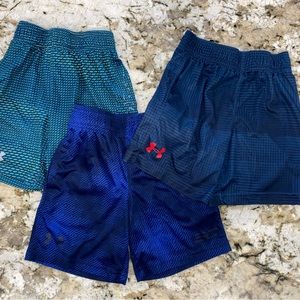 Three pairs of Under Armour size 4T. One pair is slightly faded, as shown.